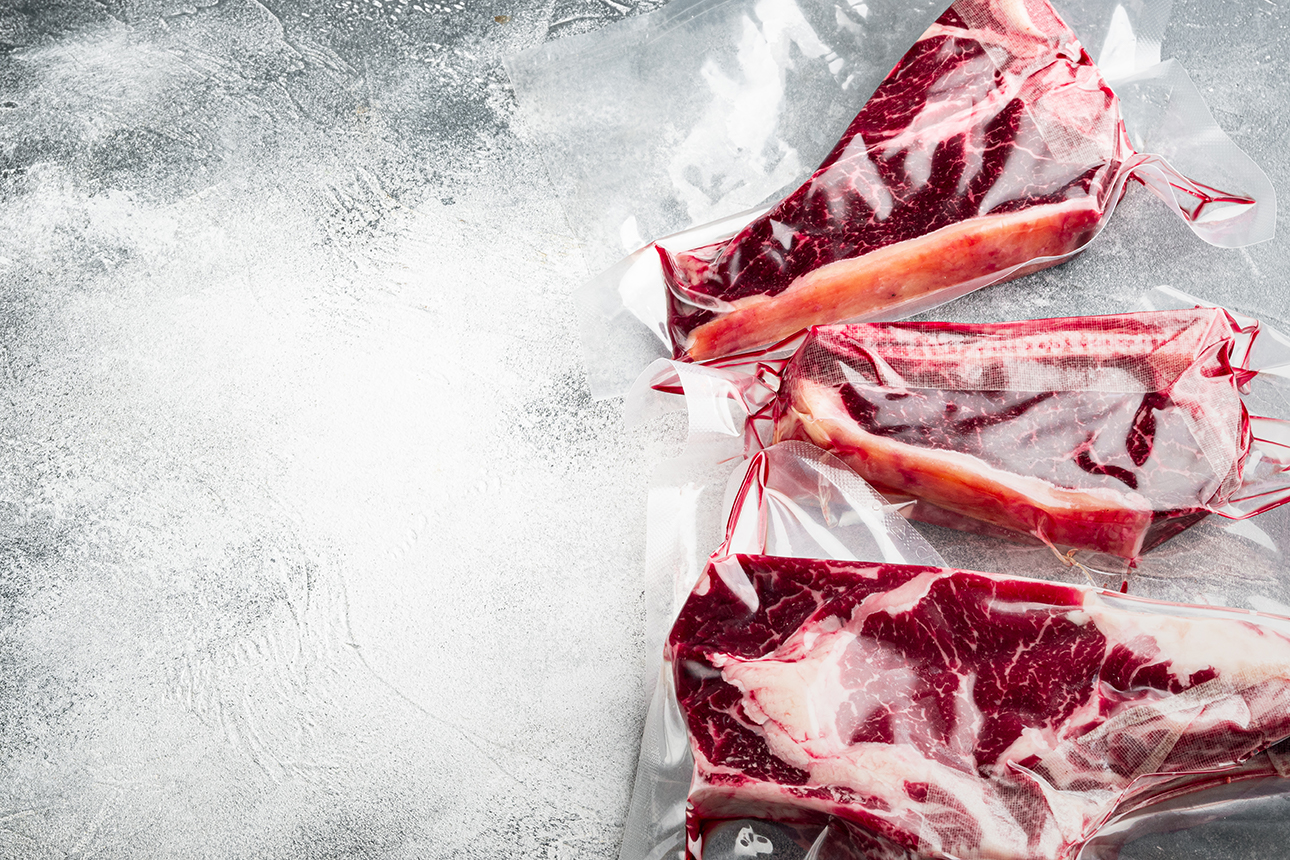 raw-beef-dry-aged-steak-vacuum-sealed-bag-for-sell-set-tomahawk-t-bone-and-club-steak-cuts-on-gray-stone-background-with-copy-space-for-text